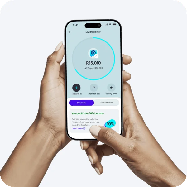 Hands holding phone showing GoalSave dream car savings screen