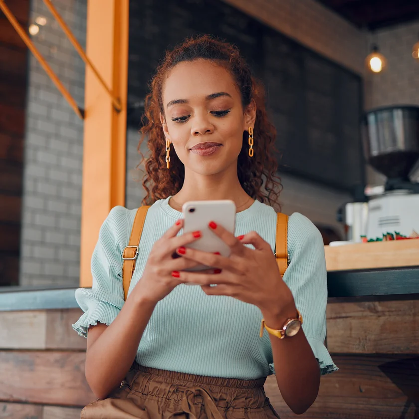 Woman using phone at cafe