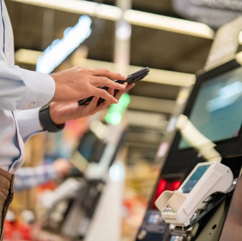 Person using phone at checkout till