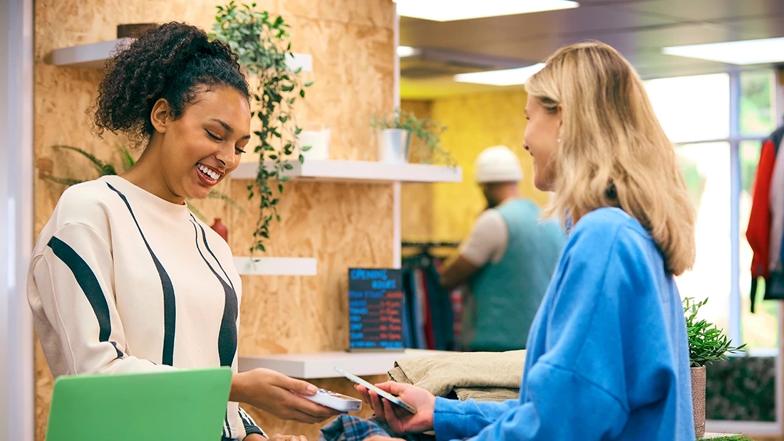 Customer paying by phone at a shop counter
