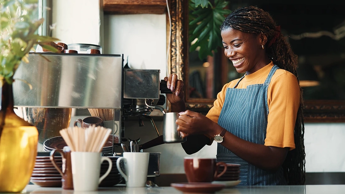 Barista preparing coffee in a busy coffee shop