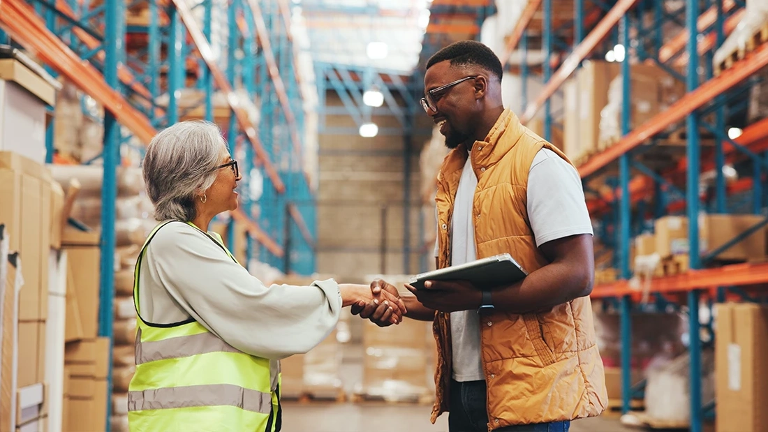 Business partners shaking hands in a warehouse