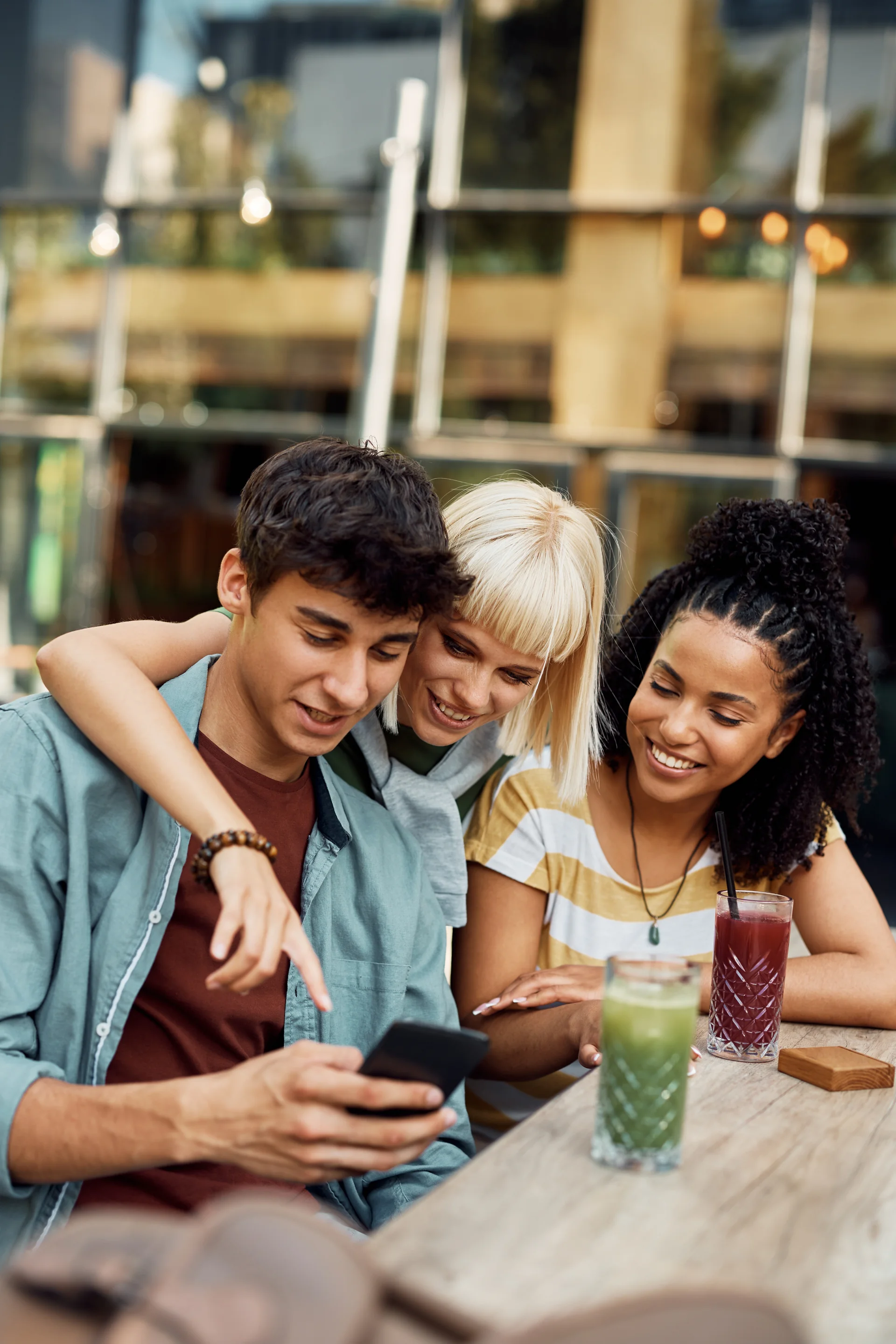 Friends looking at phone together at cafe