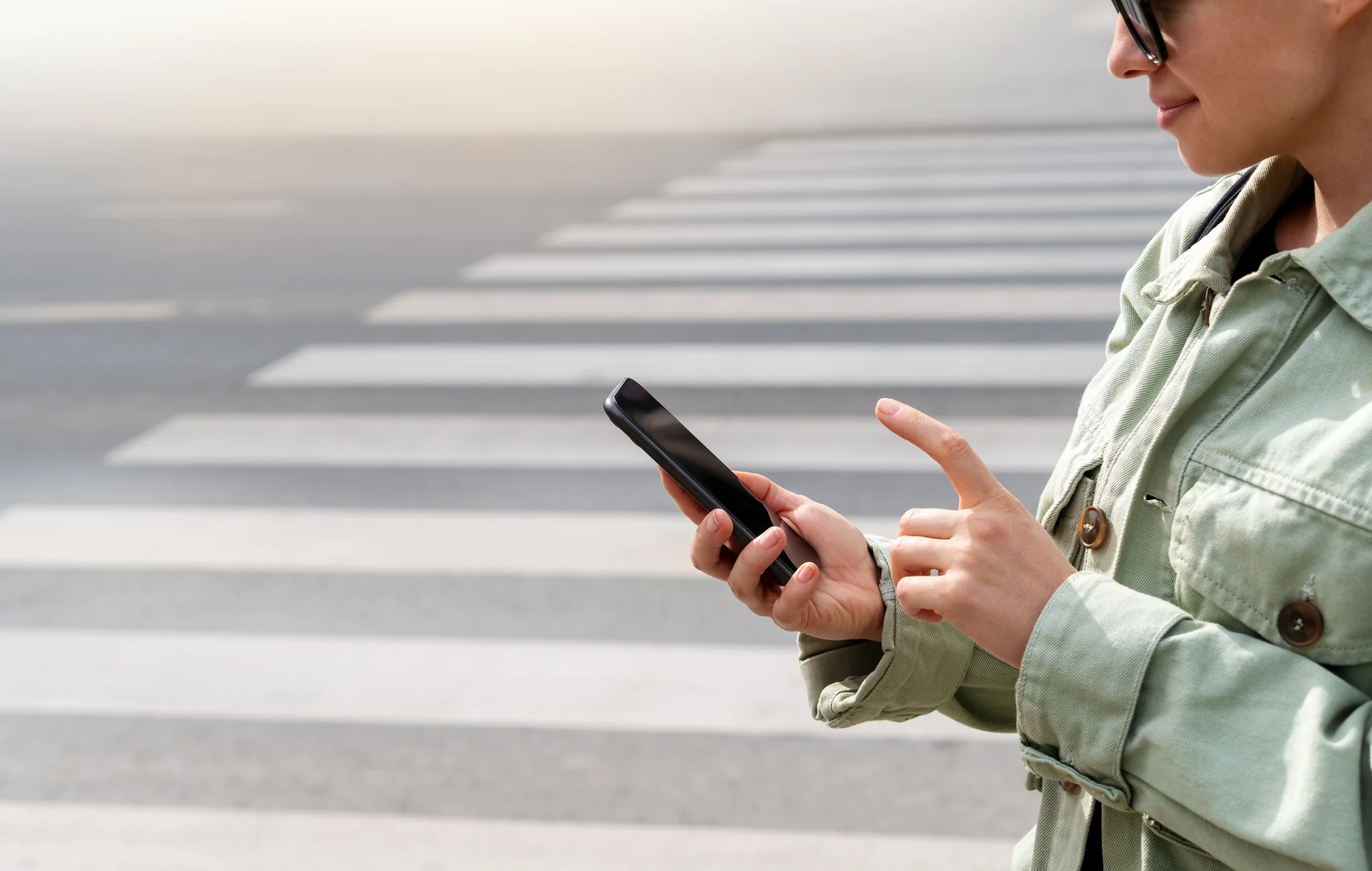 Woman using phone at crosswalk